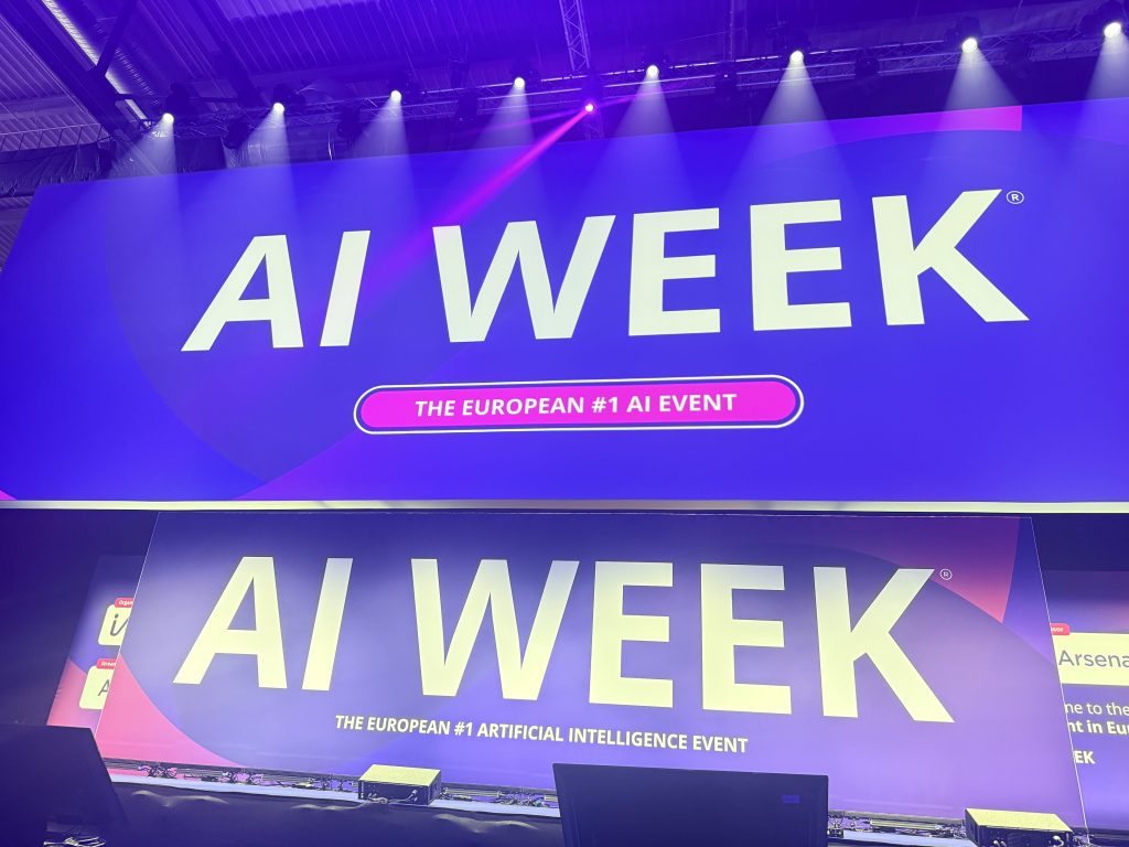 Schermi con il logo AI Week, l’evento europeo sull’intelligenza artificiale